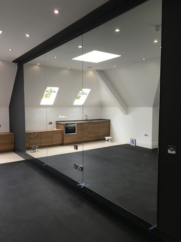 Frameless glass partition in loft conversion by Sutton glaziers